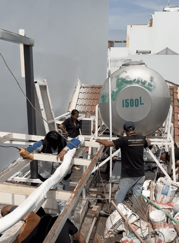 Kiến trúc sư và kỹ sư giám sát đang thảo luận về bản vẽ tại công trường xây dựng