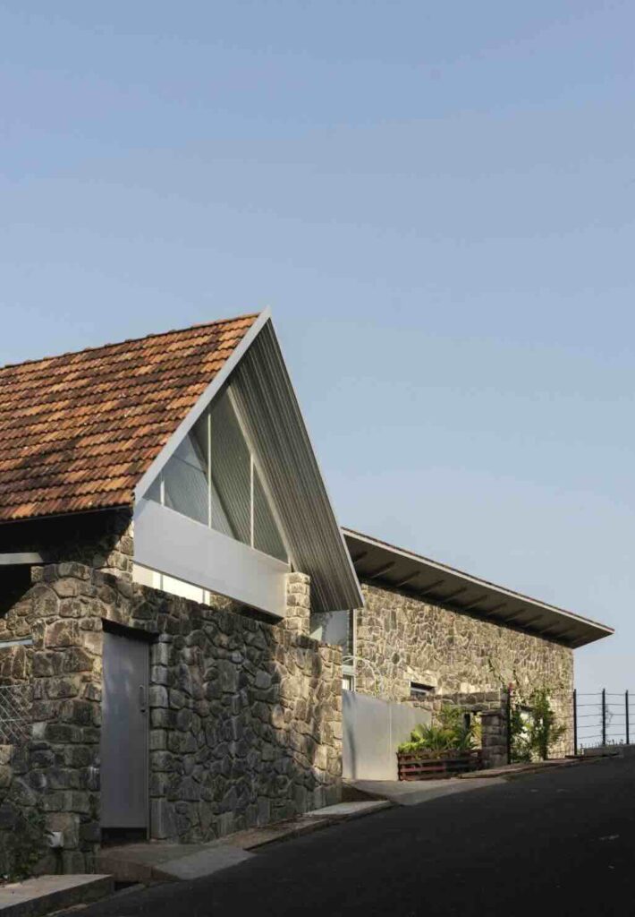 Mái nhà bằng ngói Mangalore dốc đứng phủ trên nền nhà nông trại bằng đá granit.