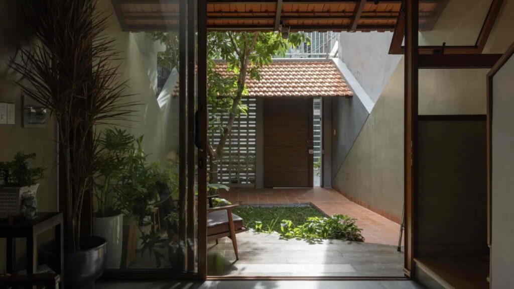 Mái nhà lợp ngói đất nung ôm lấy ngôi nhà mái hẹp ở Việt Nam do Trung Nguyên Architects thiết kế.