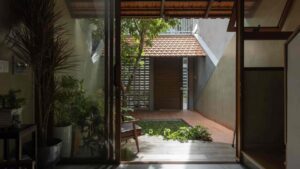 Mái nhà lợp ngói đất nung ôm lấy ngôi nhà mái hẹp ở Việt Nam do Trung Nguyên Architects thiết kế.